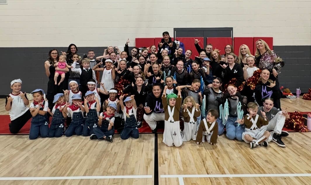 The whole studio in costume together on stage after a show