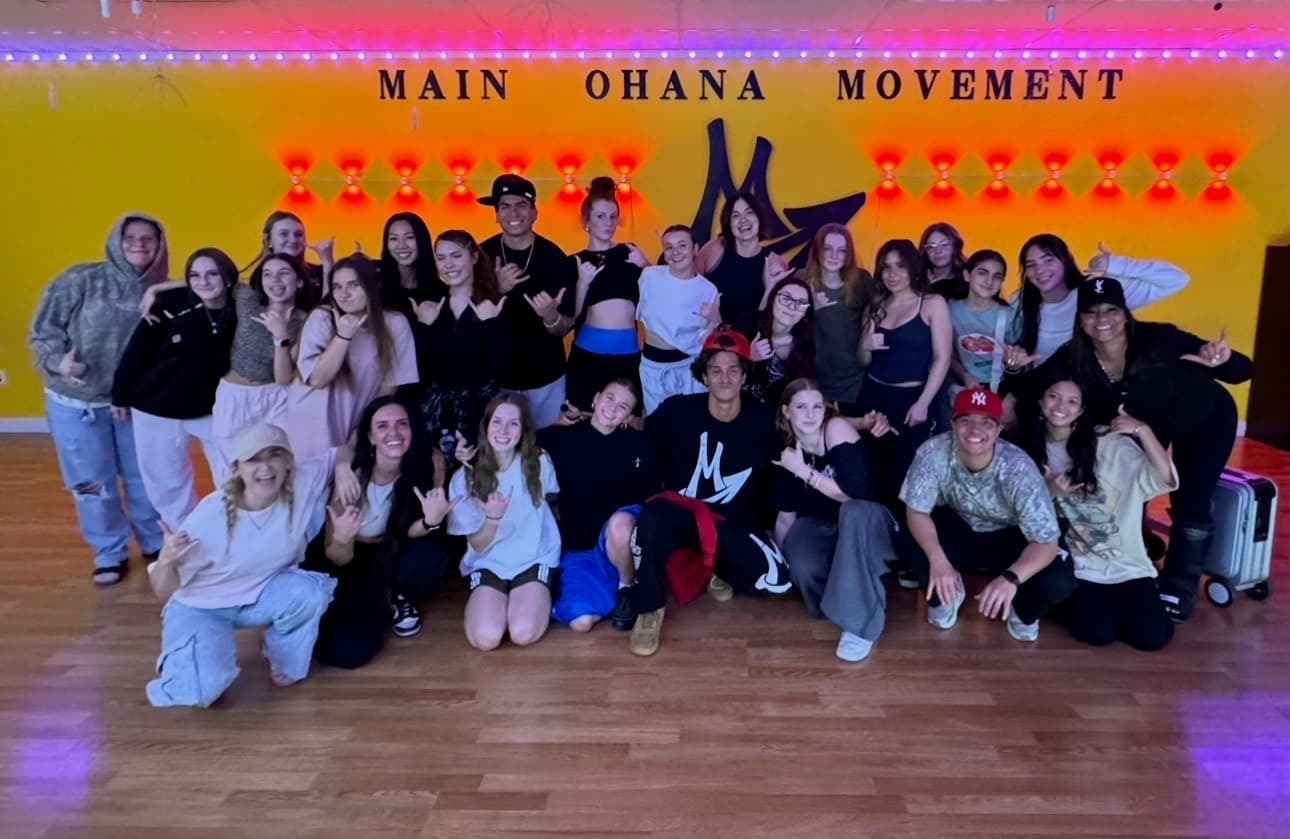 Urban Groove dancers filling the studio floor under orange and purple lights