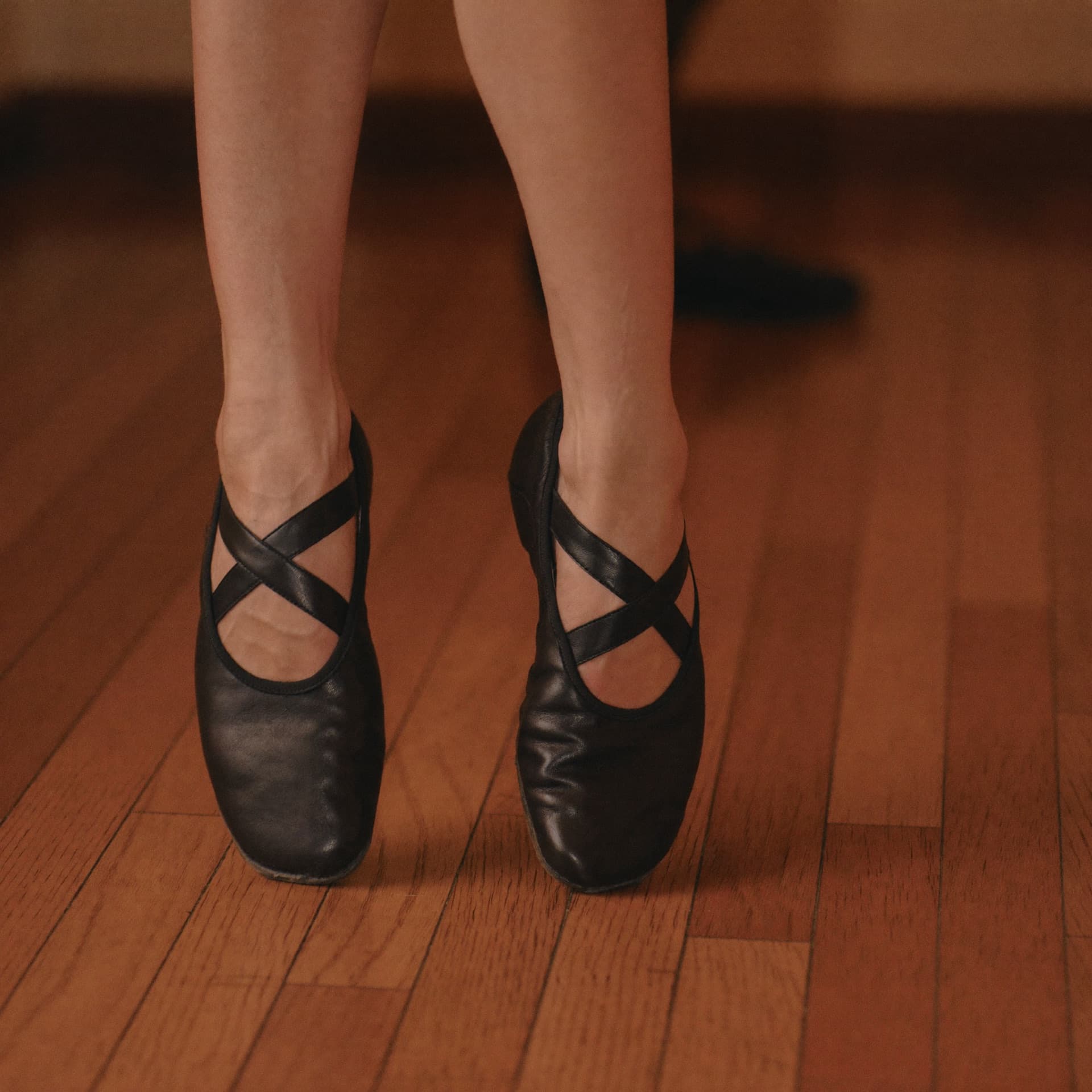 Tap shoes on the studio floor mid-step